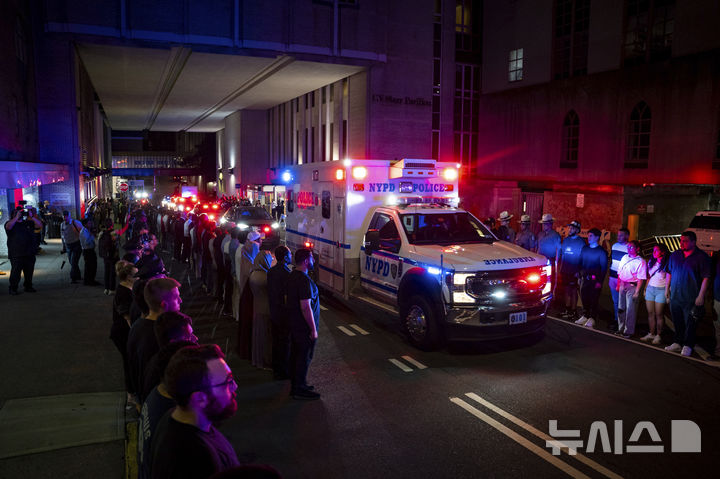[AP/뉴시스] 28일 맨해튼 오피스빌딩 총기난사범에 살해된 뉴욕 경찰관 디다럴 이슬람의 시신 앰뷸런스가 경찰 및 시민들의 애도 속에 병원에서 나오고 있다 