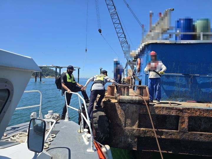 [군산=뉴시스] 해상공사 현장에 동원된 작업선에 화물 고박장치 설치 여부를 점검하기 위해 해경이 바지선으로 옮겨타고 있다. (사진=군산해경 제공) 2025.07.29. photo@newsis.com *재판매 및 DB 금지