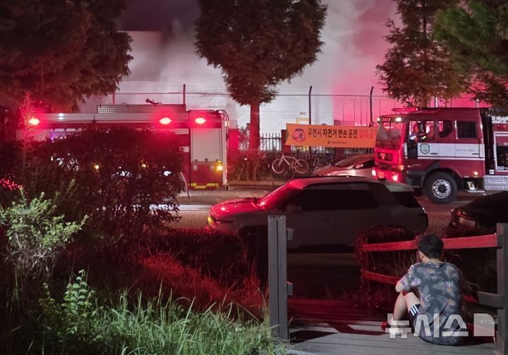 [영암=뉴시스] 28일 오후 전남 영암군 삼호읍 대불일반산업단지 HD현대삼호 내 1호사 변전소에서 불이 나 소방당국이 진화 작업을 벌이는 가운데 한 주민이 주저앉아 연기가 피어오르는 변전소를 바라보고 있다. (사진=독자 제공) 2025.07.29. photo@newsis.com