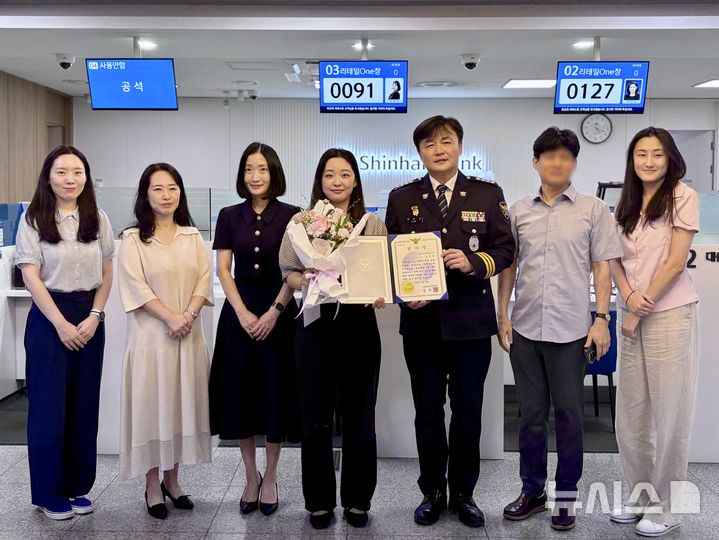 [서울=뉴시스] 지난 24일 오후 4시께 서울 마포구 신한은행 대흥역 지점에서 보이스피싱 피해를 예방한 은행원 김성하(27)씨에게 경찰이 감사장과 포상금을 수여했다. 김씨는 4시간가량의 설득으로 3200만원의 피해를 막았다. 김완기 마포경찰서장은 "보이스피싱 범죄가 날로 지능화하지만, 금융기관과 경찰이 긴밀히 협조하면 이런 피해를 충분히 막을 수 있다"고 말했다. (사진=마포경찰서 제공) 2025.07.29. photo@newsis.com