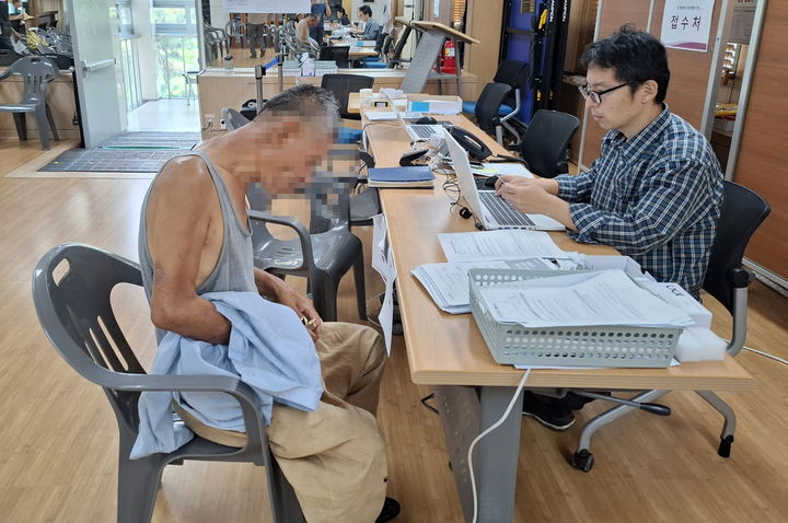 [서울=뉴시스] 전농1동주민센터에서 거리노숙인이 민생회복 쿠폰 신청하는 모습. 2025.07.29. (사진=동대문구 제공) *재판매 및 DB 금지