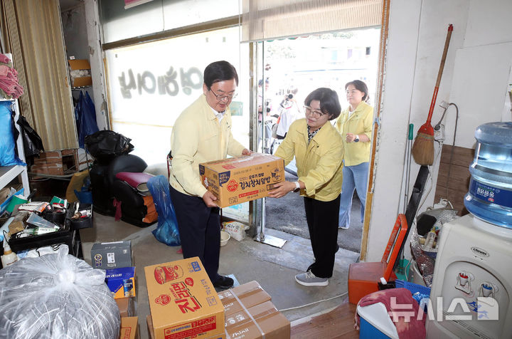 [광주=뉴시스] 29일 문인(왼쪽) 광주 북구청장과 신안동 행정복지센터 직원들이 집중 호우로 인해 피해를 입은 관내 한 세대에서 수재민을 위로하고 한국나눔연맹이 지원한 선풍기, 이불, 김치 등의 수해 의연품을 전달하고 있다. (사진=광주 북구 제공) 2025.07.29. photo@newsis.com