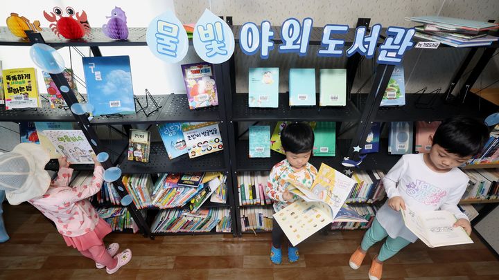 [대전=뉴시스] 대전 동구 용운동 물놀이장 내 ‘물빛 야외도서관'에서 어린이들이 책을 읽고 있다. (사진= 동구청 제공) 2025.07.29. *재판매 및 DB 금지