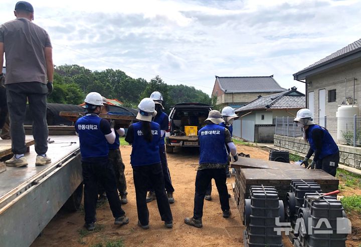 [포항=뉴시스] 송종욱 기자 = 한동대학교가 지난 3월 대형 산불로 큰 피해를 본 경북 의성군 단촌면 하화리 주민을 위해 3주간 대규모 피해 복구 봉사 활동을 했다. 사진은 봉사 활동에 나선 한동대 재학생·교직원이 산불로 소실된 집을 짓기 위해 건축 자재를 옮기는 모습. (사진=한동대 제공) 2025.07.29. photo@newsis.com
