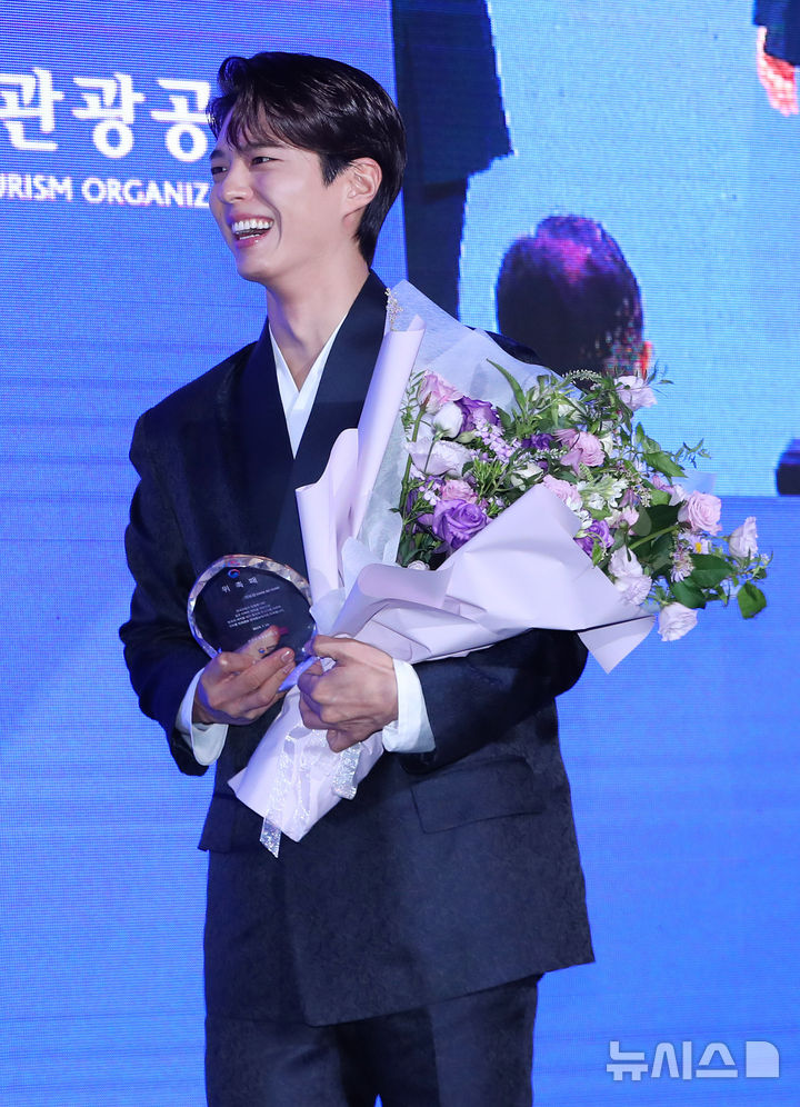 [서울=뉴시스] 김혜진 기자 = 배우 박보검이 29일 오전 서울 강남구 SJ쿤스트할레에서 열린 2025 한국 관광 명예홍보대사 위촉식에 참석해 위촉패와 꽃다발을 받고 있다. 2025.07.29. jini@newsis.com