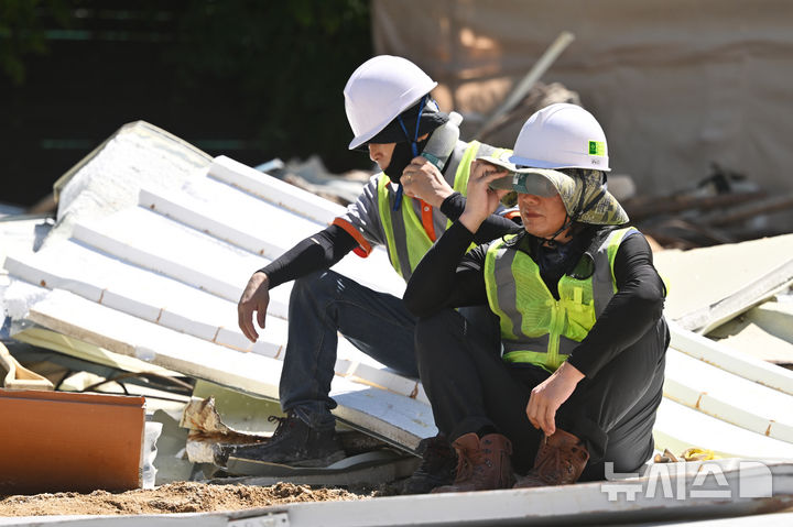 [광주=뉴시스] 이영주 기자 = 광주지역 최고기온이 36도로 예보된 29일 오전 광주 북구 옛 중흥2동 행정복지센터 철거현장에서 노동자들이 휴식시간을 이용해 물을 마시며 더위를 쫓고 있다. 광주지역에는 지난 20일 이후 현재까지 열흘 동안 폭염특보가 이어지고 있다. 2025.07.29. leeyj2578@newsis.com