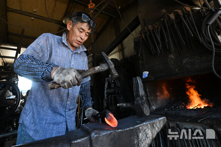 [광주=뉴시스] 이영주 기자 = 광주지역 최고기온이 37도까지 오른 29일 오후 광주 광산구 송정대장간에서 최종호(61) 송정대장간 대표가 망치와 모루를 이용해 약초를 캐는 도구를 만들고 있다. 광주지역에는 지난 20일 이후 현재까지 열흘 동안 폭염특보가 이어지고 있다. 2025.07.29. leeyj2578@newsis.com