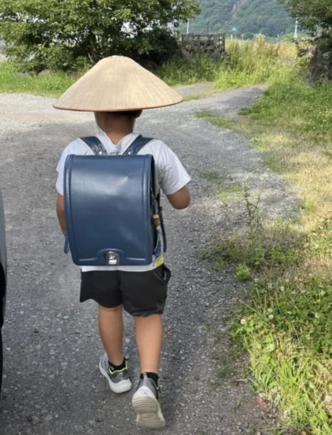 [서울=뉴시스] 일본서 머리에 쓰는 '삿갓형 양산'이 인기를 끌고 있다. 화제가 된 초등학생의 모습. (사진 = 엑스 캡처) 2025.07.30. *재판매 및 DB 금지