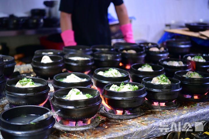 [광주=뉴시스] 이현행 기자 = 삼복더위 중 두 번째 복날을 맞은 29일 오전 광주 서구 치평동 한 삼계탕 전문점에서 뚝배기에 담긴 삼계탕이 활활 타오르는 불길 위에서 준비되고 있다. 2025.07.30. lhh@newsis.com 