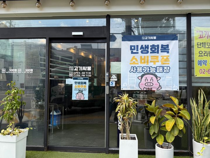 [서울=뉴시스]성예진 인턴기자=서울 영등포구 신길동에 있는 고기 무한 리필 매장 앞에 ‘민생 회복 소비 쿠폰 사용 가능 매장’이라는 현수막이 크게 걸려있다. 2025.07.30 photo@newsis.com *재판매 및 DB 금지