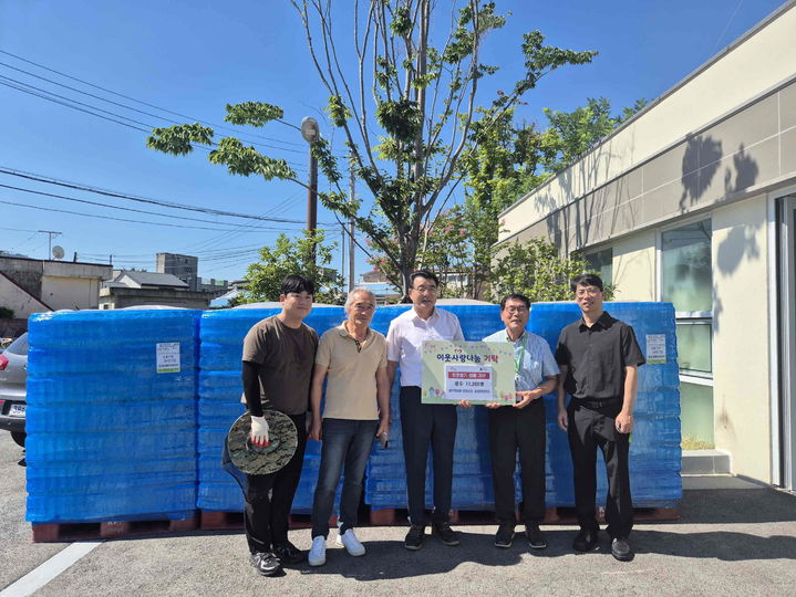 [밀양=뉴시스] 이성용(오른쪽) 풀무원샘물 공장장과 김주갑(왼쪽 두 번째) 일랑문화복지센터 위원장이 생수 1만1200병을 기탁하고 있다. (사진=밀양시 제공) 2025.07.30. photo@newsis.com *재판매 및 DB 금지