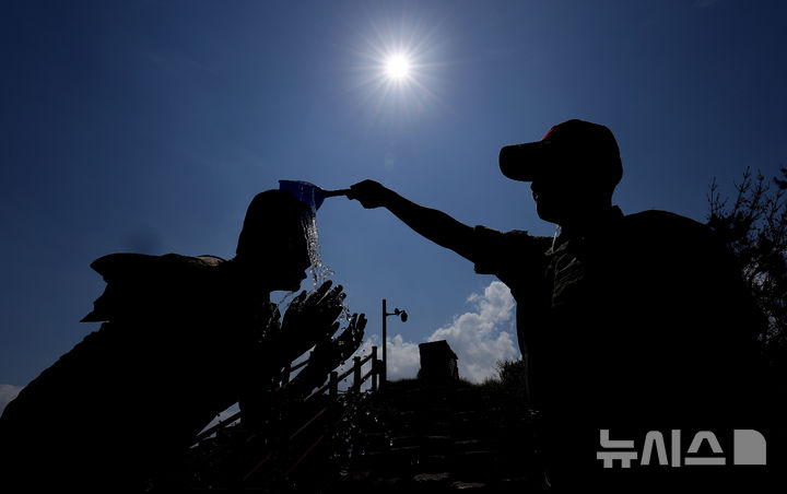 [포항=뉴시스] 이무열 기자 = 30일 경북 포항시 남구 해병대 훈련장에서 열린 2025 여름 해병대 캠프에 참여한 한 학생이 교관이 뿌리는 물을 맞으며 더위를 식히고 있다. 2025.07.30. lmy@newsis.com