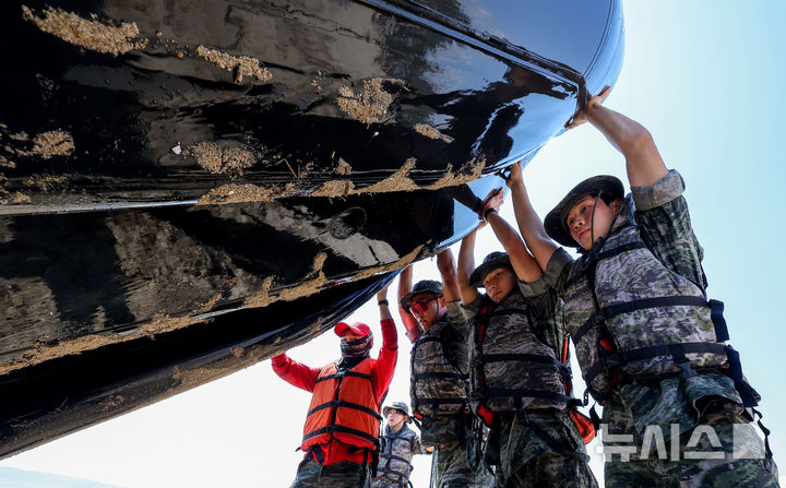 [포항=뉴시스] 이무열 기자 = 30일 경북 포항시 남구 해병대 훈련장에서 열린 2025 여름 해병대 캠프에 참여한 학생들이 IBS(소형고무보트) 체험 후 보트에 남은 물을 빼고 있다. 2025.07.30. lmy@newsis.com