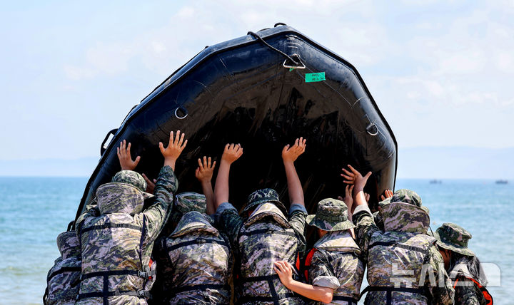[포항=뉴시스] 이무열 기자 = 30일 경북 포항시 남구 해병대 훈련장에서 열린 2025 여름 해병대 캠프에 참여한 학생들이 IBS(소형고무보트) 체험 후 보트에 남은 물을 빼고 있다. 2025.07.30. lmy@newsis.com