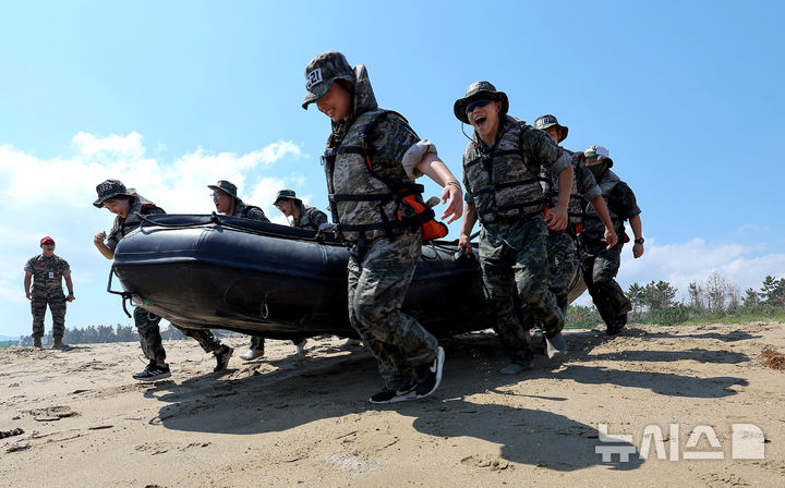 [포항=뉴시스] 이무열 기자 = 30일 경북 포항시 남구 해병대 훈련장에서 열린 2025 여름 해병대 캠프에 참여한 학생들이 IBS(소형고무보트)를 들고 바다로 뛰어들고 있다. 2025.07.30. lmy@newsis.com