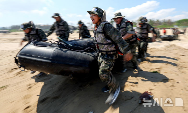 [포항=뉴시스] 이무열 기자 = 30일 경북 포항시 남구 해병대 훈련장에서 열린 2025 여름 해병대 캠프에 참여한 학생들이 IBS(소형고무보트)를 들고 바다로 뛰어들고 있다. 2025.07.30. lmy@newsis.com