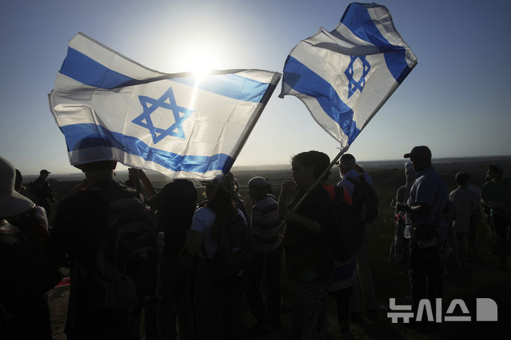 [이스라엘 남부=AP/뉴시스] 7월 30일 이스라엘 남부 가자지구 접경 지역에서 이스라엘 극우 활동가들이 국기를 들고 유대인 정착촌 재건 촉구 행진을 하고 있다. 2025.09.05.