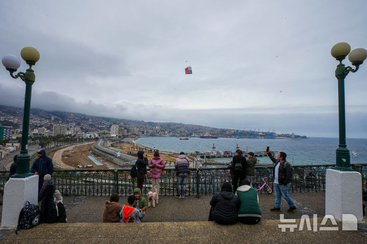 [발파라이소=AP/뉴시스] 2025년 7월 30일 러시아 캄차카반도에서 발생한 지진으로 예방 차원의 쓰나미 경보가 발령된 칠레 발파라이소에서 바론 전망대에 모인 사람들이 바다를 바라보고 있다. 2026.02.09.