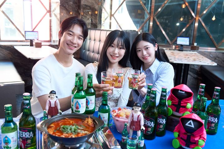 [서울=뉴시스] 하이트진로 모델들이 '테라·참이슬 오징어 게임 에디션' 제품과 굿즈를 함께 즐기고 있다.(사진=하이트진로 제공) *재판매 및 DB 금지
