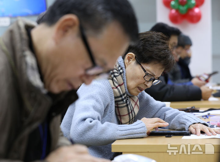[서울=뉴시스] 박미소 수습기자 = 2018년 서울시 금천구청 전산교육실에서 열린 ‘어르신 스마트 과거시험’에 참여한 어르신 응시생들이 스마트폰으로 문제를 풀고 있다. 2018.12.17. misocamera@newsis.com **기사 내용과 관련 없습니다**