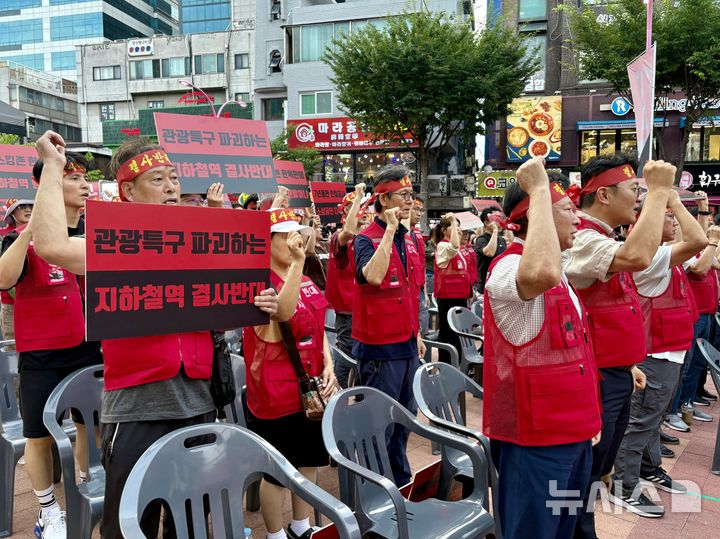 [서울=뉴시스] 한이재 기자 = 31일 오후 서울 마포구 레드로드 내에서 홍대상인회와 대장홍대선 레드로드역사 반대 비상대책위원회가 대장홍대선 레드로드역사 반대 기자회견을 열었다. 참가자들이 구호를 외치며 손을 드는 모습이다. 2025.07.31. nowone@newsis.com