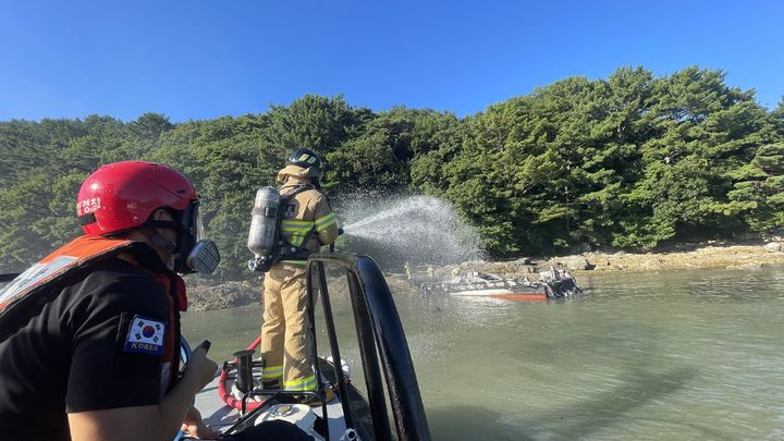 [거제=뉴시스] 신정철 기자= 통영해양경찰서는 31일 오후 4시 33분께 경남 거제시 남부면 탑포항에 정박 계류중인 선박에서 화재가 발생, 어선 2척이 전소되고 어선 1척과 바지선 2척이 불탔다.사진은 통영해경 구조대원이 불타는 어선에 대해 진화작업을 펼치고 있는 모습.(사진=통영해경 제공).2025.07.31. photo@newsis.com *재판매 및 DB 금지