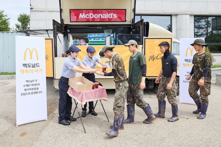 [서울=뉴시스] 가평 지역 수해 복구에 참여한 군 장병들이 맥카페 음료트럭 앞에서 버거와 음료를 수령하고 있다.(사진=한국맥도날드 제공) *재판매 및 DB 금지