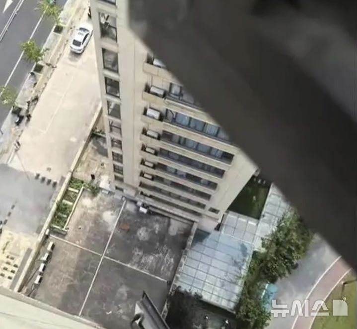 [뉴시스] 3살 아이가 추락한 아파트 18층 방 창문에서 아래를 내려다본 모습. (출처=SCMP) 