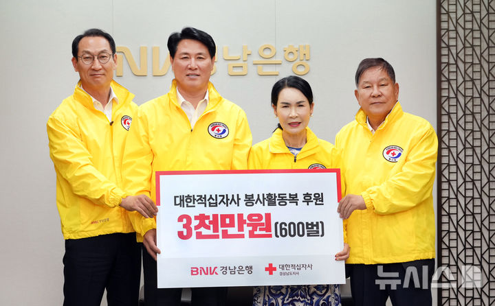[창원=뉴시스]7월 31일 BNK경남은행 창원 본점에서 김태한 은행장(왼쪽서 두번째부터)이 대한적십자사 경남지사 박희순 회장, 최충경 자문위원에게 3000만 원 상당 봉사활동복 기탁증서를 전달하고 있다.(사진=BNK경남은행 제공) 2025.08.01. photo@newsis.com