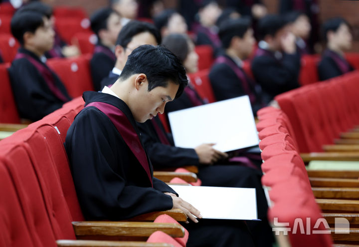 [과천=뉴시스] 김진아 기자 =  1일 경기 정부과천청사 법무부에서 열린 2025 하반기 신임검사 임관식에서 한 신임 검사가 임명장을 보고 있다. 2025.08.01. bluesoda@newsis.com