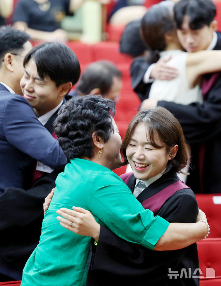 [과천=뉴시스] 김진아 기자 =  1일 경기 정부과천청사 법무부에서 열린 2025 하반기 신임검사 임관식에서 신임 검사들이 부모님과 포옹을 하고 있다. 2025.08.01. bluesoda@newsis.com