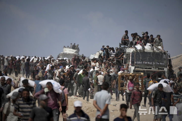 [베이트 라히야=AP/뉴시스] 3일(현지 시간) AP통신에 따르면 이타마르 벤그비르 이스라엘 국가안보부 장관은 이날 알아크사 사원을 찾아 가자지구 병합과 팔레스타인 주민들의 이주를 촉구했다. 사진은 1일(현지 시간) 가자지구 북부 베이트 라히야 외곽에서 팔레스타인 주민들이 가자시티로 향하던 인도적 물품 수송 트럭에서 내린 밀가루 자루를 나르고 있다. 2025.08.04.