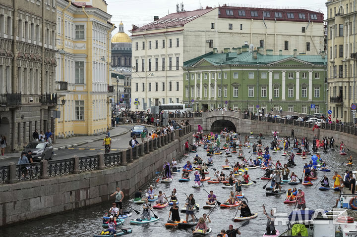 [상트페테르부르크=AP/뉴시스] 2일(현지 시간) 러시아 상트페테르부르크 모이카강에서 비가 내리는 가운데 열린 연례 ‘폰탄카’ 스탠드업 패들보드(SUP) 축제 참가자들이 패들보드를 젓고 있다. 이 축제에는 1만 명이 넘는 참가자가 함께했다. 2025.08.04.