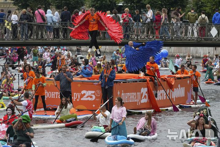 [상트페테르부르크=AP/뉴시스] 2일(현지 시간) 러시아 상트페테르부르크 모이카강에서 비가 내리는 가운데 열린 연례 ‘폰탄카’ 스탠드업 패들보드(SUP) 축제 참가자들이 패들보드를 젓고 있다. 이 축제에는 1만 명이 넘는 참가자가 함께했다. 2025.08.04.
