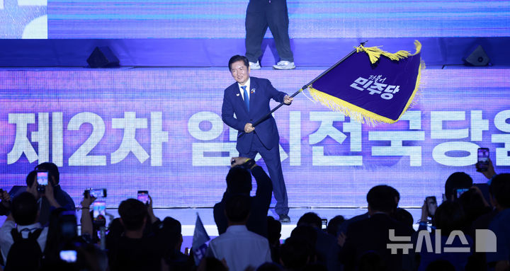 [고양=뉴시스] 고승민 기자 = 정청래 신임 더불어민주당 대표가 2일 경기 고양 킨텍스에서 열린 더불어민주당 제2차 임시전국당원대회에서 당기를 흔들고 있다. 2025.08.02. kkssmm99@newsis.com