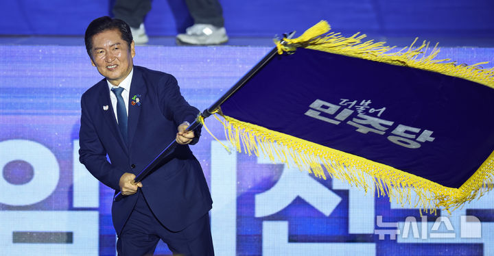 [고양=뉴시스] 고승민 기자 = 정청래 더불어민주당 신임 당대표가 2일 경기 고양시 킨텍스에서 열린 제2차 임시전국당원대회에서 당기를 흔들고 있다. (공동취재) 2025.08.02. photo@newsis.com