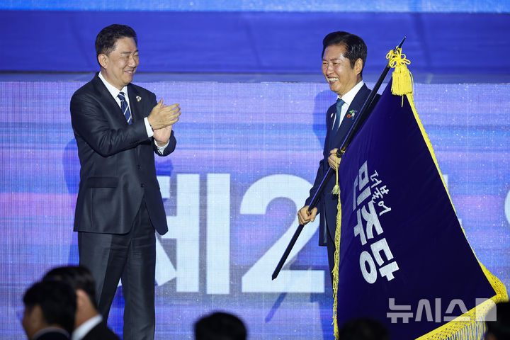 [고양=뉴시스] 고승민 기자 = 정청래 더불어민주당 신임 당대표가 2일 경기 고양시 킨텍스에서 열린 제2차 임시전국당원대회에서 김병기 원내대표로 부터 당기를 이양받고 있다. (공동취재) 2025.08.02. photo@newsis.com