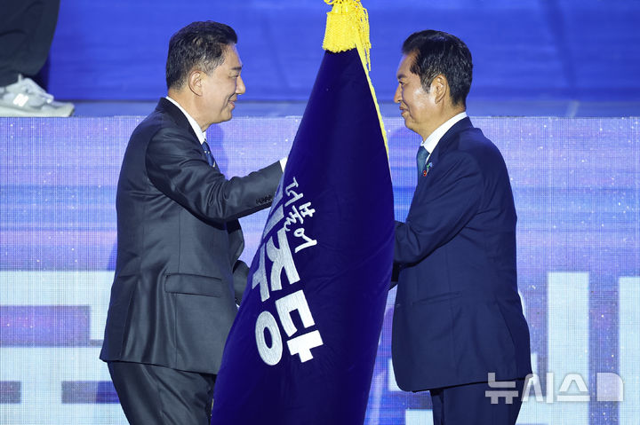 [고양=뉴시스] 고승민 기자 = 정청래 더불어민주당 신임 당대표가 2일 경기 고양시 킨텍스에서 열린 제2차 임시전국당원대회에서 김병기 원내대표로 부터 당기를 이양받고 있다. (공동취재) 2025.08.02. photo@newsis.com