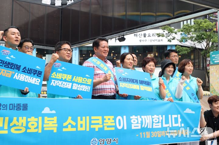 [안양=뉴시스] 안양시가 최근 관내 평촌 1번가 문화의거리에서 민생회복 소비쿠폰 촉진 캠페인을 한 가운데 최대호 시장(사진 가운데) 등 참석자들이 ‘소비 쿠폰’ 사용 구호를 외치고 있다. (사진=안양시 제공).2025.08.03.photo@newsis.com 
