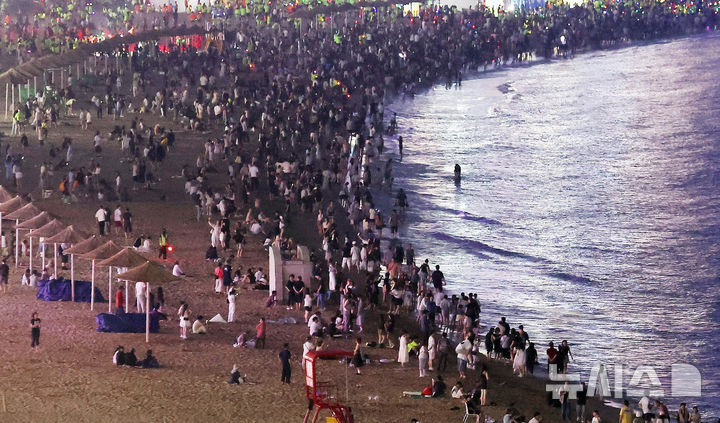  [부산=뉴시스] 하경민 기자 = 폭염특보와 열대야 현상으로 밤낮 가리지 않고 푹푹 찌는 더위가 이어진 2일 밤 부산 수영구 광안리해수욕장에서 시민과 관광객들이 더위를 식히고 있다. 2025.08.03. yulnetphoto@newsis.com