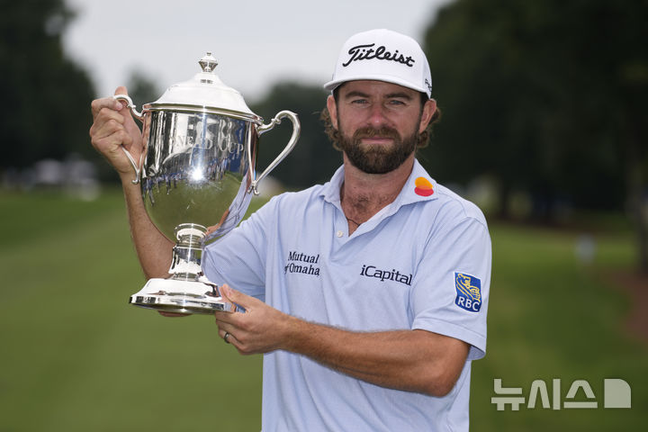 [그린즈버러=AP/뉴시스] 캐머런 영(미국)이 3일(현지 시간) 미 노스캐롤라이나주 그린즈버러의 세지필드 컨트리클럽에서 열린 미국프로골프(PGA) 투어 윈덤 챔피언십 정상에 올라 트로피를 들고 포즈를 취하고 있다. 영은 최종 합계 22언더파 258타로 투어 첫 우승컵을 들어 올렸다. 2025.08.04.