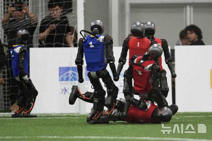 [베이징=AP/뉴시스] 4일(현지 시간) 중국 베이징에서 '2025 세계 휴머노이드 로봇 게임'을 앞두고 언론 공개 행사가 열린 가운데 부스터 휴머노이드 로봇들이 축구 시범 경기로 기술을 선보이고 있다. 오는 14일부터 17일까지 열리는 이 행사에는 축구를 비롯해 달리기, 격투, 댄스 등 실제 사람의 경기와 유사한 종목이 포함된 것으로 알려졌다. 2025.08.04.