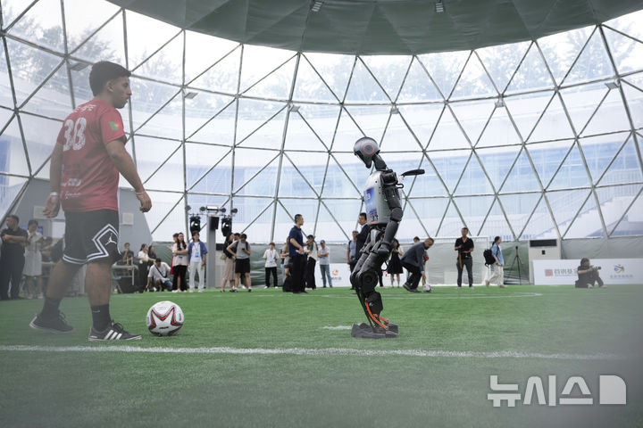 [베이징=AP/뉴시스] 4일(현지 시간) 중국 베이징에서 '2025 세계 휴머노이드 로봇 게임'을 앞두고 언론 공개 행사가 열린 가운데 부스터 휴머노이드 로봇들이 축구 시범 경기로 기술을 선보이고 있다. 오는 14일부터 17일까지 열리는 이 행사에는 축구를 비롯해 달리기, 격투, 댄스 등 실제 사람의 경기와 유사한 종목이 포함된 것으로 알려졌다. 2025.08.05.