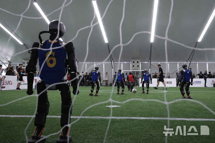 [베이징=AP/뉴시스] 4일(현지 시간) 중국 베이징에서 '2025 세계 휴머노이드 로봇 게임'을 앞두고 언론 공개 행사가 열린 가운데 부스터 휴머노이드 로봇들이 축구 시범 경기로 기술을 선보이고 있다. 오는 14일부터 17일까지 열리는 이 행사에는 축구를 비롯해 달리기, 격투, 댄스 등 실제 사람의 경기와 유사한 종목이 포함된 것으로 알려졌다. 2025.08.05.