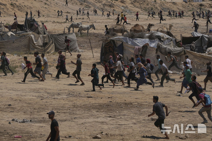 [자와이다=AP/뉴시스] 4일(현지 시간) 가자지구 중부 자와이다에서 팔레스타인 주민들이 낙하산으로 투하되는 인도적 지원 물품을 받기 위해 몰려들고 있다. 2025.08.05.