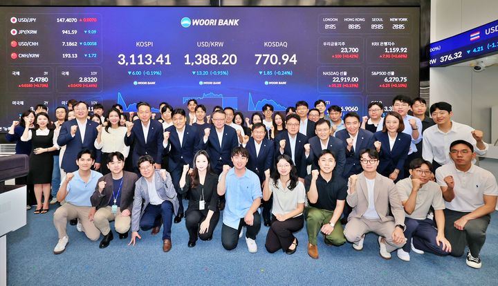 4일 우리은행 회현동 본점 자금시장그룹 딜링룸 전광판 점등식에 정진완 은행장(두 번째 줄 가운데)과 임직원들이 참석해 기념촬영을 하고 있다. (사진=우리은행 제공) *재판매 및 DB 금지