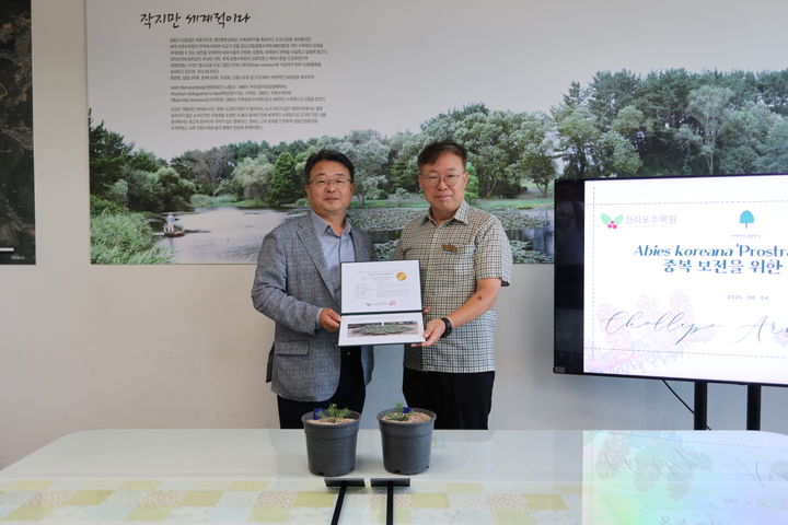 [태안=뉴시스] 4일 태안 천리포수목원에서 열린 구상나무 중복 보전을 위한 기증식에서 김건호 (왼쪽)천리포수목원장이 고경찬 국립백두대간수목원 본부장에게 구상나무 혈통증명서를 건네고 있다. (사진=천리포수목원 제공) 2025.08.04. photo@newsis.com *재판매 및 DB 금지