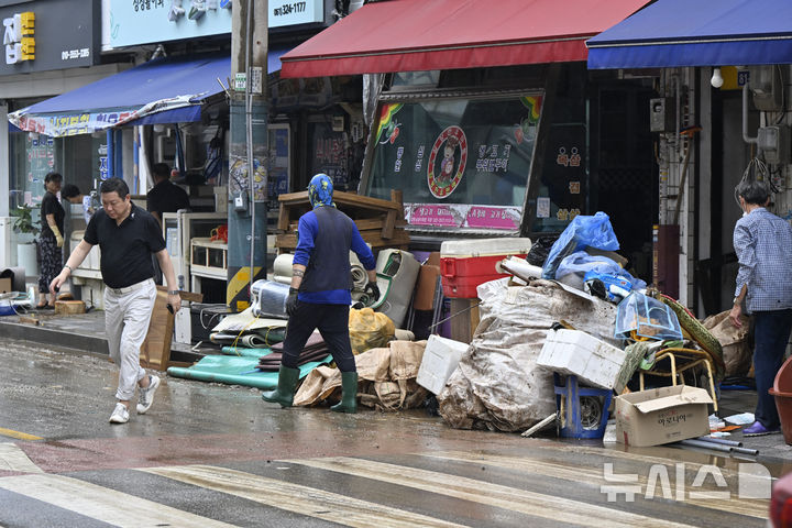 [함평=뉴시스] 박기웅 기자 = 4일 오전 전남 함평군 함평읍 상가 거리에서 주민들이 침수 피해를 입은 상가 복구 작업을 벌이고 있다. 함평에는 전날 많은 비가 내리면서 주택 50가구와 상가 46곳이 침수된 것으로 잠정 집계됐다. 2025.08.04. pboxer@newsis.com