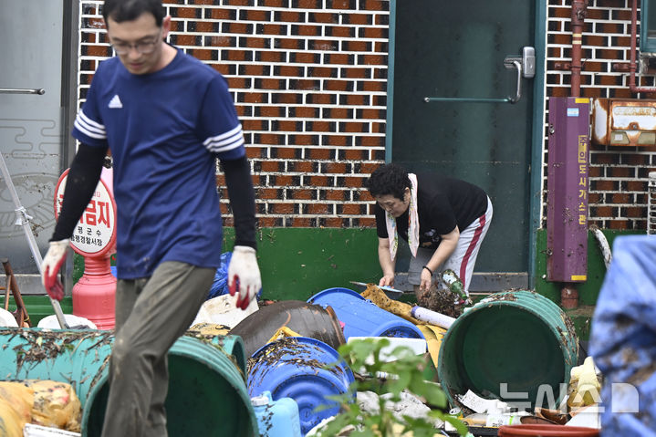 [함평=뉴시스] 박기웅 기자 = 4일 오전 전남 함평군 함평읍 한 주택 앞에서 주민들이 폭우에 떠밀려 온 쓰레기들을 치우고 있다. 함평에는 전날 많은 비가 내리면서 주택 50가구와 상가 46곳이 침수된 것으로 잠정 집계됐다. 2025.08.04. pboxer@newsis.com