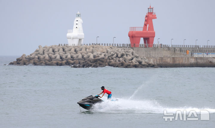 [제주=뉴시스] 우장호 기자 = 제주 해안가 전역에 폭염주의보가 발효된 4일 오전 제주시 이호테우해수욕장에서 피서객이 수상레저기구를 타고 있다. 2025.08.04. woo1223@newsis.com